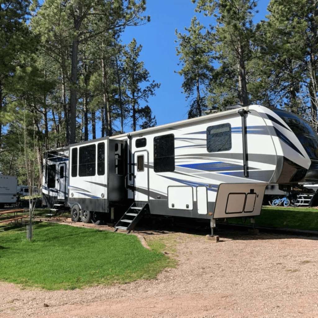RV parked in spot among pine trees in the Black Hills at Beaver Lake RV Resort in Custer, SD