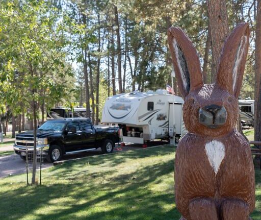 RV Campground Site with view of Wooden Rabbit View of Wooden Rabbit fixture with RV Campsite in Background