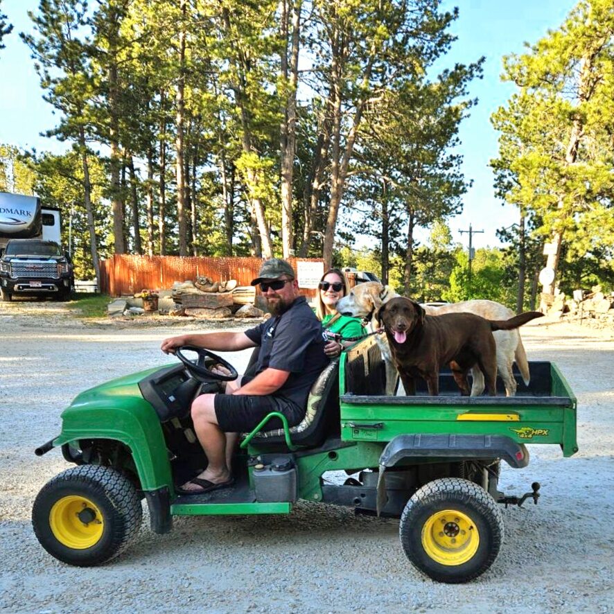 Couple with Dogs riding ATV around Beaver Lake Campground in Custer, SD