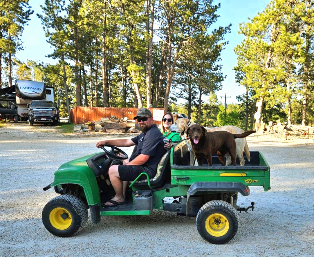 Couple with Dogs riding ATV around Beaver Lake Campground in Custer, SD