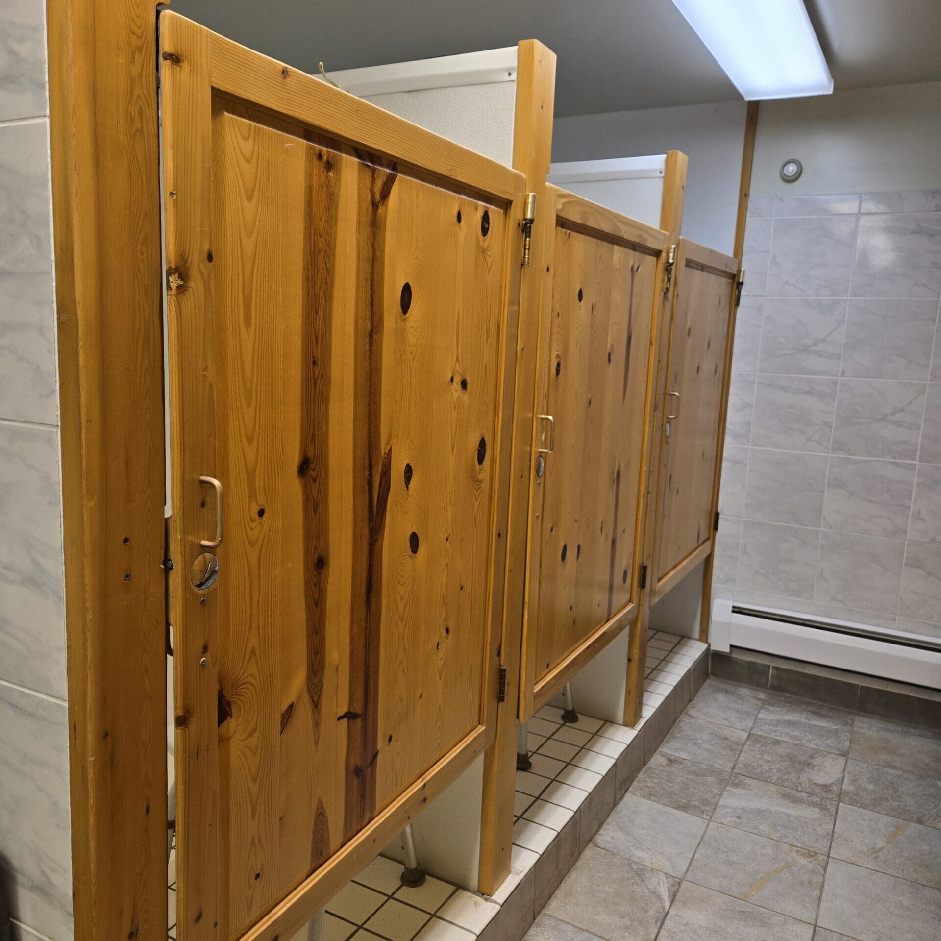 Interior of a bathhouse at Beaver Lake Campground with multiple shower units